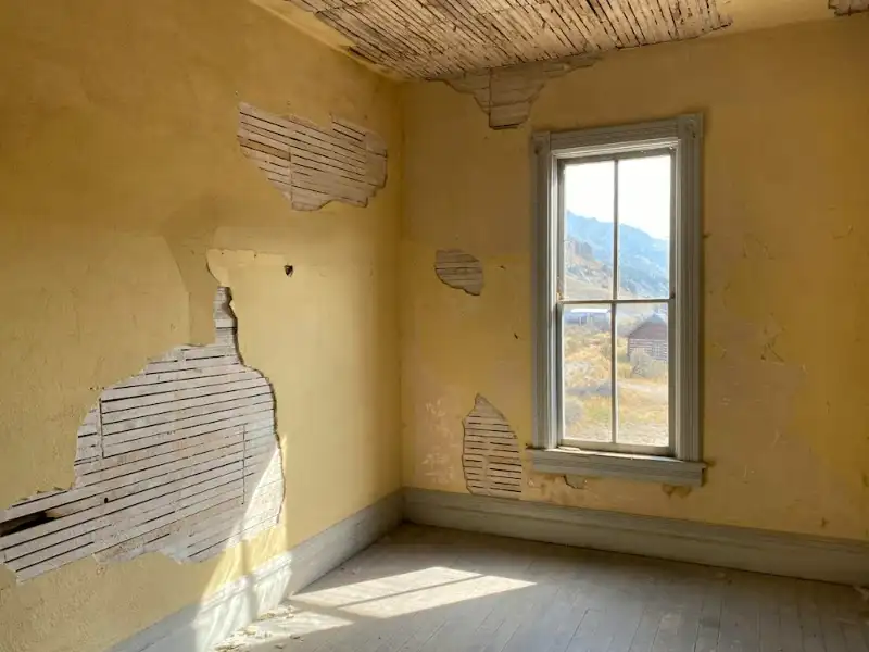 Pièce aux murs abîmés, enduit qui se décolle