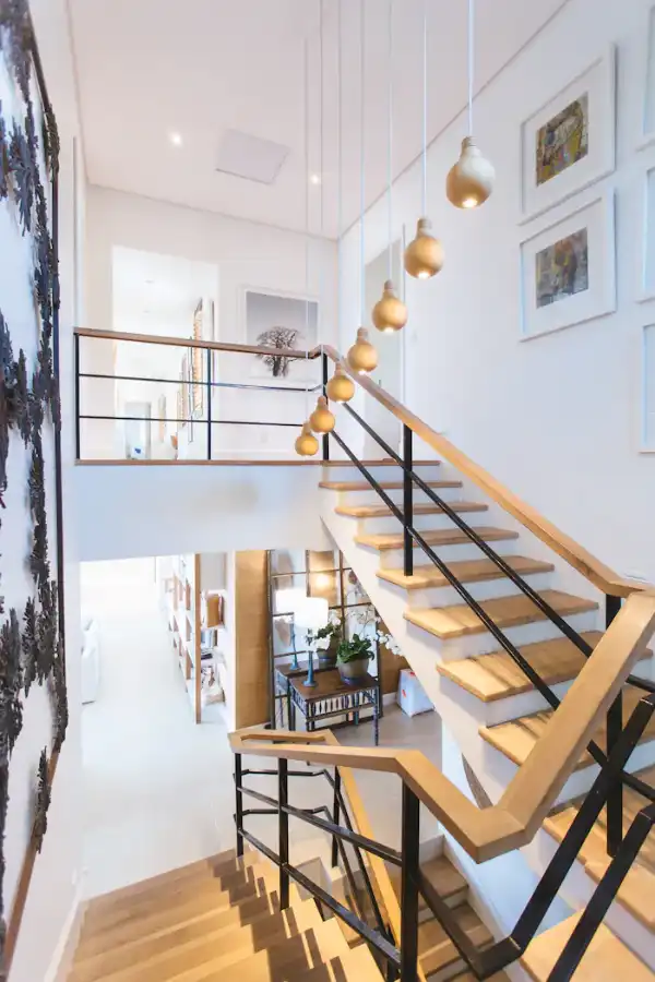Escalier en bois et verre dans un hall blanc